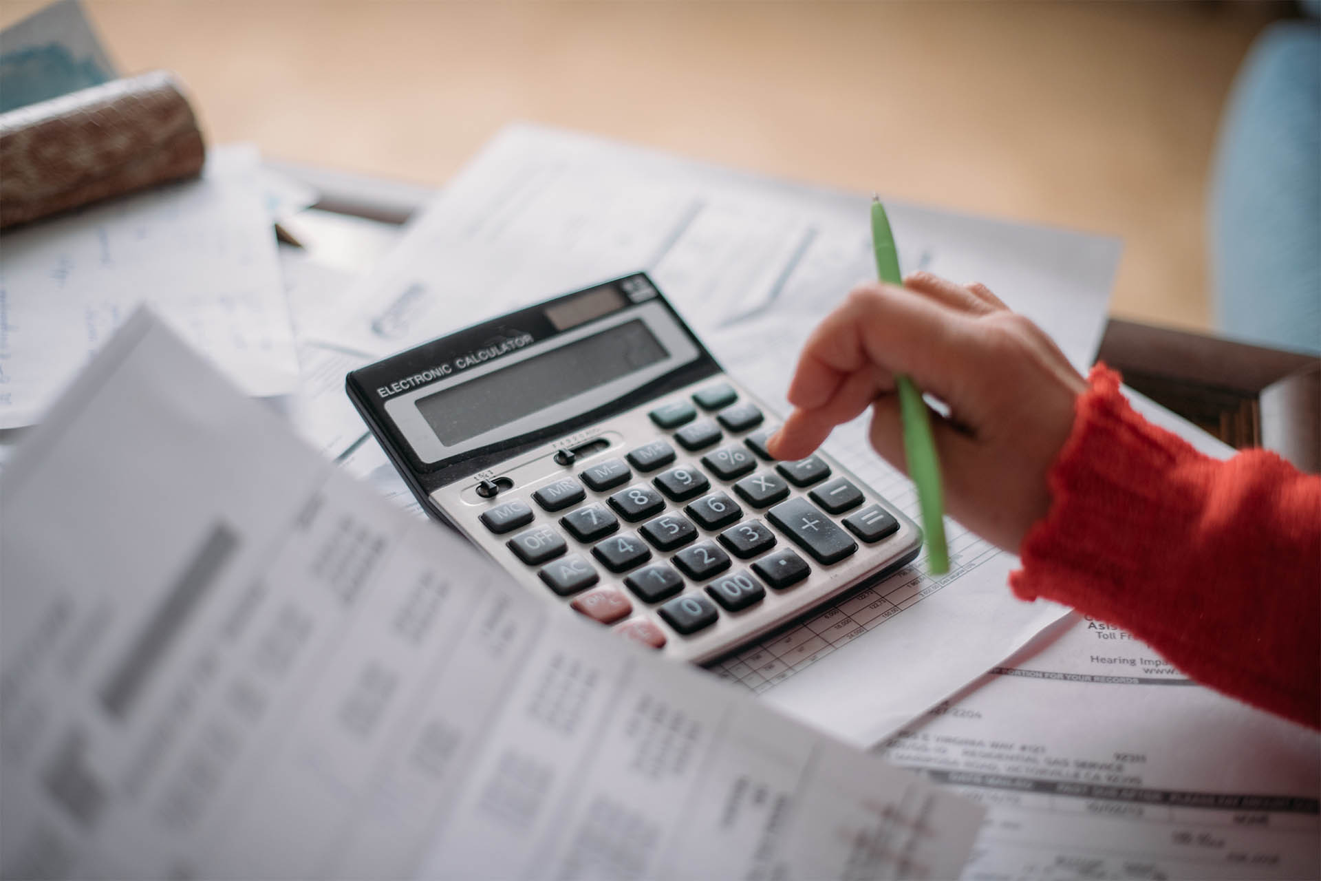 woman using calculator to balance financial documents